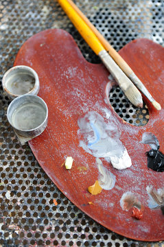 Painter's palette with paintbrushes and oil painting