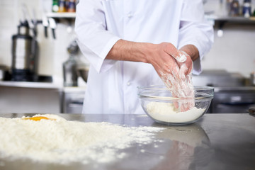 Chef making dough from flour and raw eggs on table