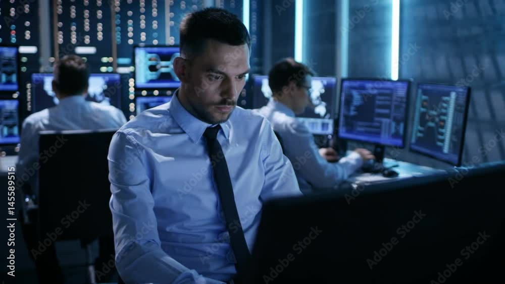 Leinwandbilder Close-up of Operations Engineer Working on His Computer With Multiple Displays in Monitoring Room. Shot on RED EPIC-W 8K Helium Cinema Camera.