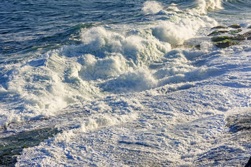 Waves and sea foam over the stone