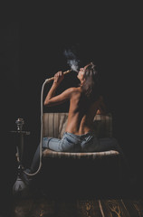 sexy girl with naked body smoking hookah in jeans