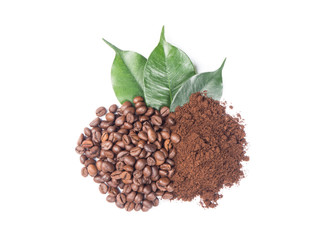 Pile of ground and coffee beans with green leaves from top view