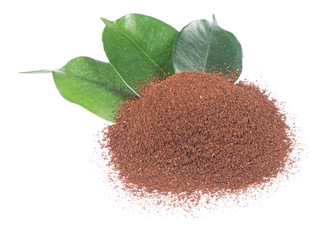 Pile of ground coffee with green leaves from top view