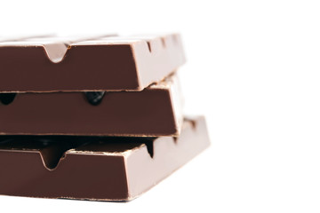 Three pieces of bitter, dark chocolate bar, isolated on white background, close-up, side view
