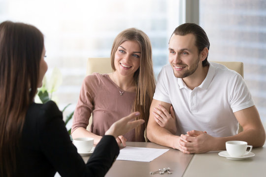 Family couple meeting with female real estate agent to choose property for buying or renting, considering mortgage loan, young man and woman want to buy own house, rear view at realtor