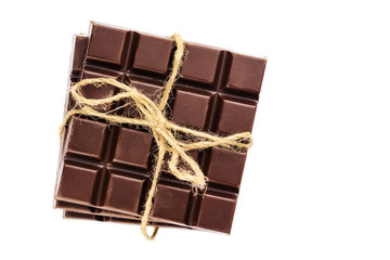 Three pieces of bitter, dark chocolate bar bound by twine, isolated on white background, close-up, top view