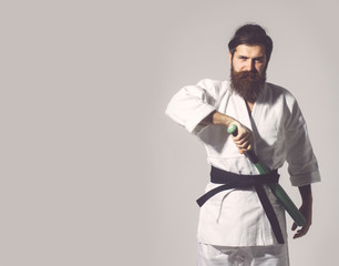 bearded smiling karate man in kimono with green baseball bat