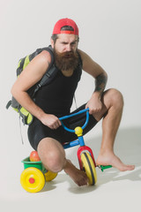 bearded angry man with bag, apple on bicycle toy