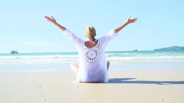 junge, blonde Frau macht Yoga am Strand