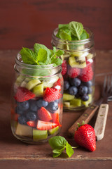 Fototapeta na wymiar fruit salad in mason jar strawberry blueberry kiwi apple mint