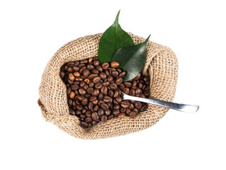 Roasted coffee beans,metal spoon and green leaves in sack from top view over white isolated background