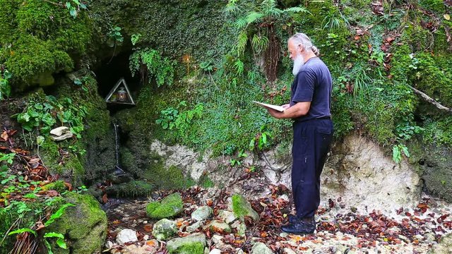 The old pilgrim read the prayer at holy spring 