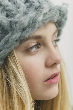 Pretty young girl with blond hair in fashionable hat