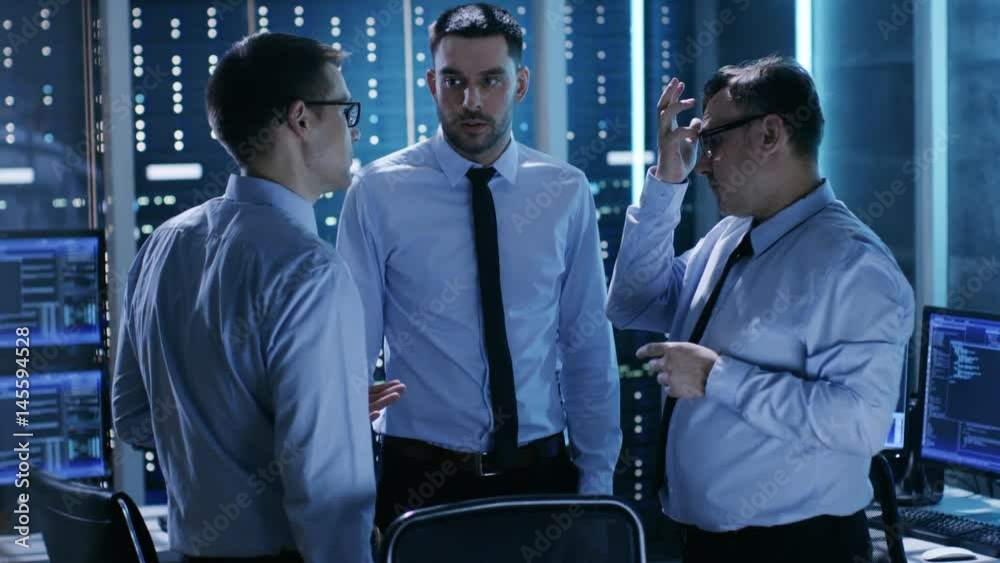 Aufkleber three male technical controllers have active discussion in monitoring room. system control room is f