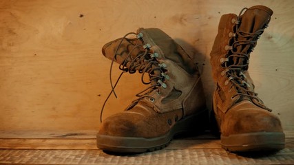 Old military boots on a wooden table