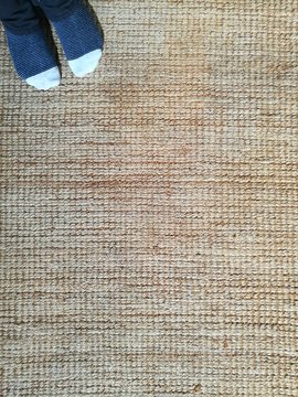 Kleiner Junge mit Ringelsocken auf Teppichboden ausNaturfasern in Beige und Naturfarben einem Landhaus in Alacati bei Cesme am &Auml;g&auml;ischen Meer in der Provinz Izmir in der T&uuml;rkei