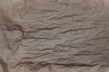 A crumpled burned vintage paper texture (old and burnt material, brown and wrinkled).
