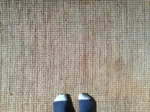 Kinderf&uuml;&szlig;e mit Ringelsocken auf Teppichboden aus Naturfasern in Beige und Naturfarben in einem Landhaus in Alacati bei Cesme am &Auml;g&auml;ischen Meer in der Provinz Izmir in der T&uuml;rkei
