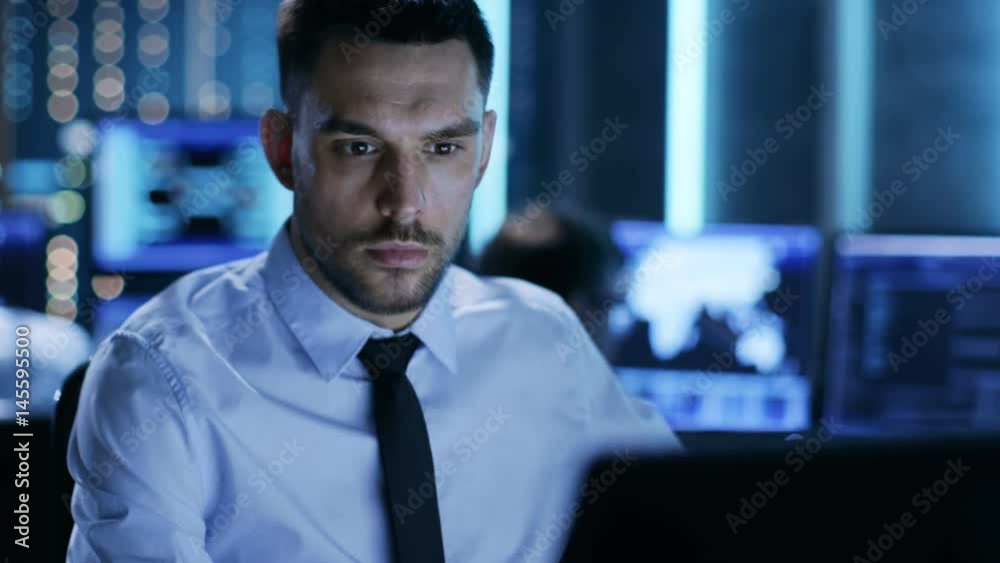 Aufkleber close-up of a professional technical controller sitting at his desk with multiple displays before hi