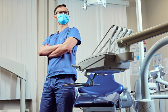 Dentist in a room with medical equipment on background.