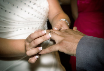 Obraz na płótnie Canvas Close up hands of bride and groom putting on a wedding rings