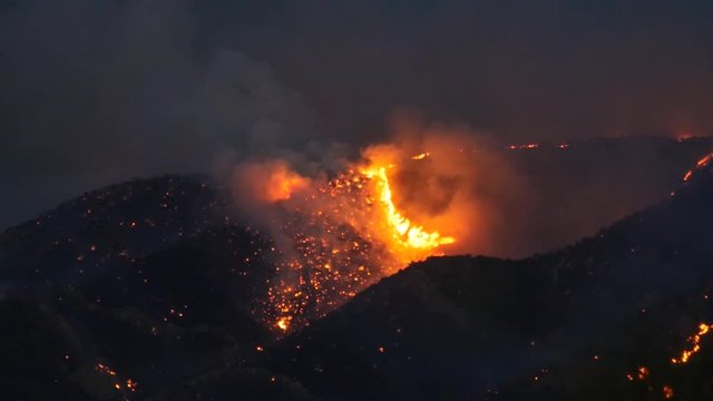 A mountain wildfire burning at night