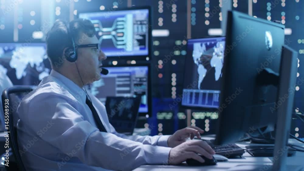 Poster Professional Technical Support Personnel Working in a System Control Center. We See Many Working Displays with Various Data Visible on Them.  Shot on RED EPIC-W 8K Helium Cinema Camera.