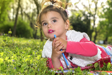 The little girl draws in nature