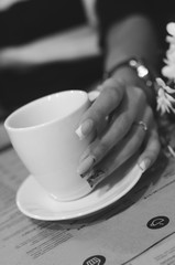 Only one hand beauty woman holding a cup of coffe. Black and white
