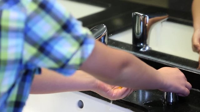 Child washing hands with soap. Real time full hd video footage.