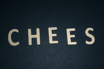 Chees written with colorful wooden letters on a blue background