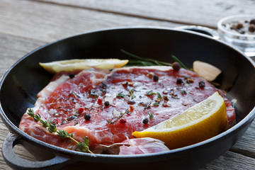 Raw beef steak closeup background with spices and herbs.