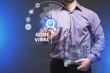 Business, Technology, Internet and network concept. Young businessman working on a virtual screen of the future and sees the inscription: Gone viral