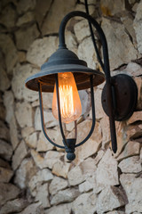 Vintage outdoor lamp on the stone wall home close up.