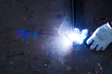 Worker welding steel with sparks using mig mag welder