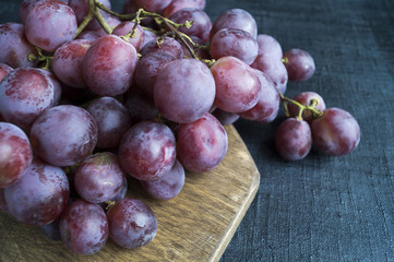 grapes on a wooden Board. on a black background