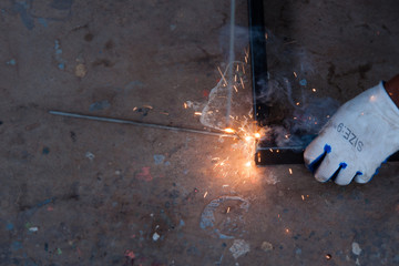 Worker welding steel with sparks using mig mag welder