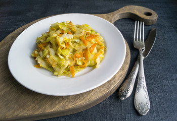 cabbage braised in white plate on black background