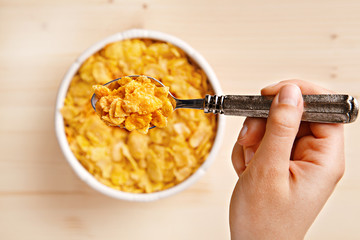 Eating fresh cornflakes. Cereals breakfast in a bowl from above. Top view