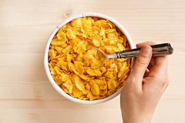 Eating fresh cornflakes. Cereals breakfast in a bowl from above. Top view
