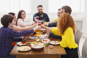 People say cheers clink glasses at festive table dinner party
