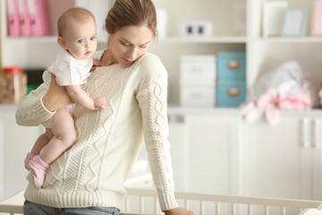 Depressed young woman with cute baby at home