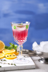 Glass of delicious wine spritzer on color background