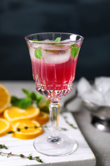 Glass of delicious wine spritzer on black background