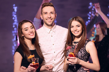 Friends with tasty cocktails at party in night club