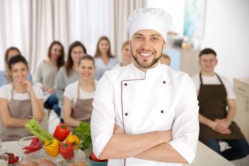 Male chef and group of people at cooking classes