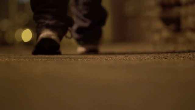 Man's sports shoes walking alone in the street at night