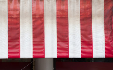 dirty red and white striped awning of shop