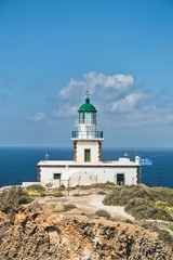 Fototapeta na wymiar Akrotiri lighthouse at sunny morning with picturesque clouds, Santorini island, Greece