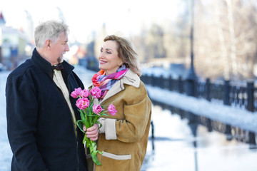 Happy senior couple with bouquet of flowers  on a walk © Africa Studio